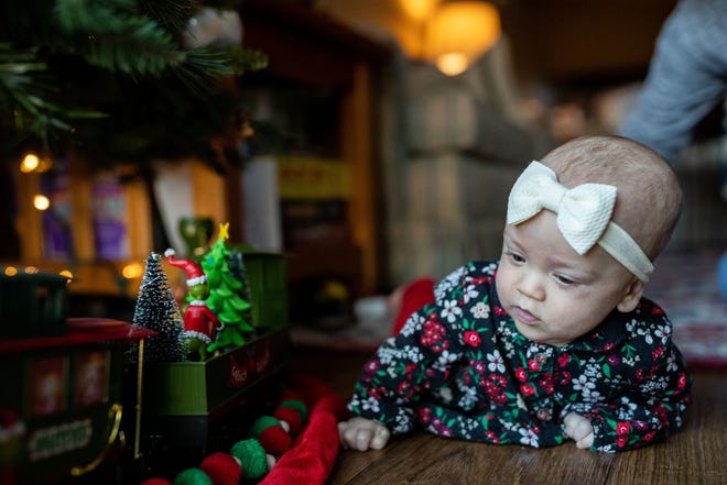 Grace, who was born prematurely at Tallahassee Memorial HealthCare, looks at a Grinch train that circles the family Christmas tree in her home Friday, Dec. 16, 2022. Grace was released from the TMH NICU just in time for her first Christmas. 