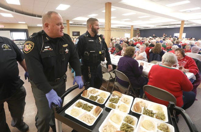 Muskingum County Sheriff Matt Lutz, left, and Zanesville Police Department Lt. Derek Shilling look for seniors to serve during the annual FOP Dinner at the Muskingum County Center for Seniors on Friday.