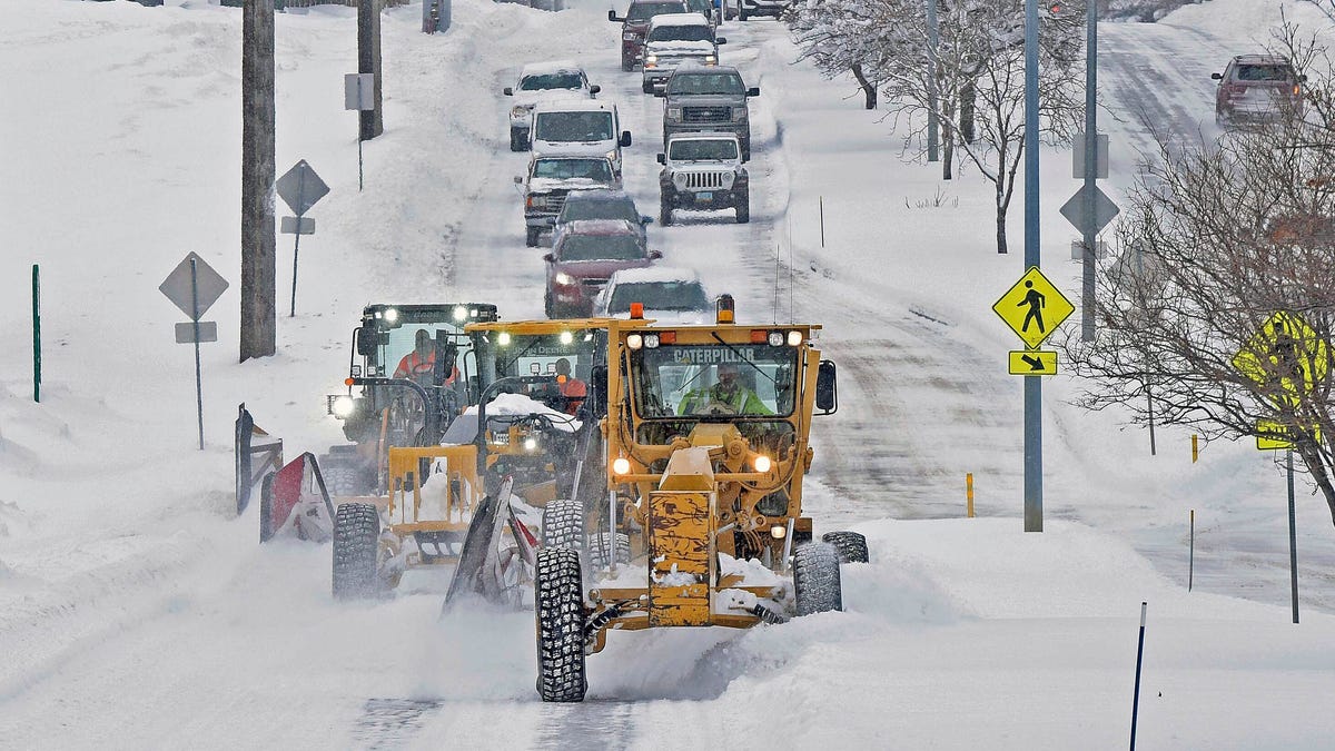 A trio of City of Bismarck snow plows clear Century Ave. near Jaycee Park on Friday afternoon, Dec. 16, 2022, followed by a line of vehicles in Bismarck, N.D.