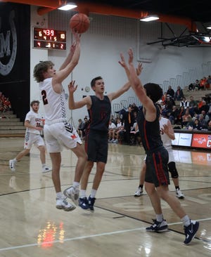 Meadowbrook senior Easton Eibel (2) gets off a shot over Morgan's Rowdy Williams (10) and Hayden Shriver (2) during Friday's MVL game in Byesville.
