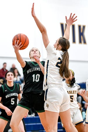 Williamston's Claire Casey, left, shoots a layup as Haslett's Emily Homan defends during the third quarter on Friday, Dec. 16, 2022, at Haslett High School.