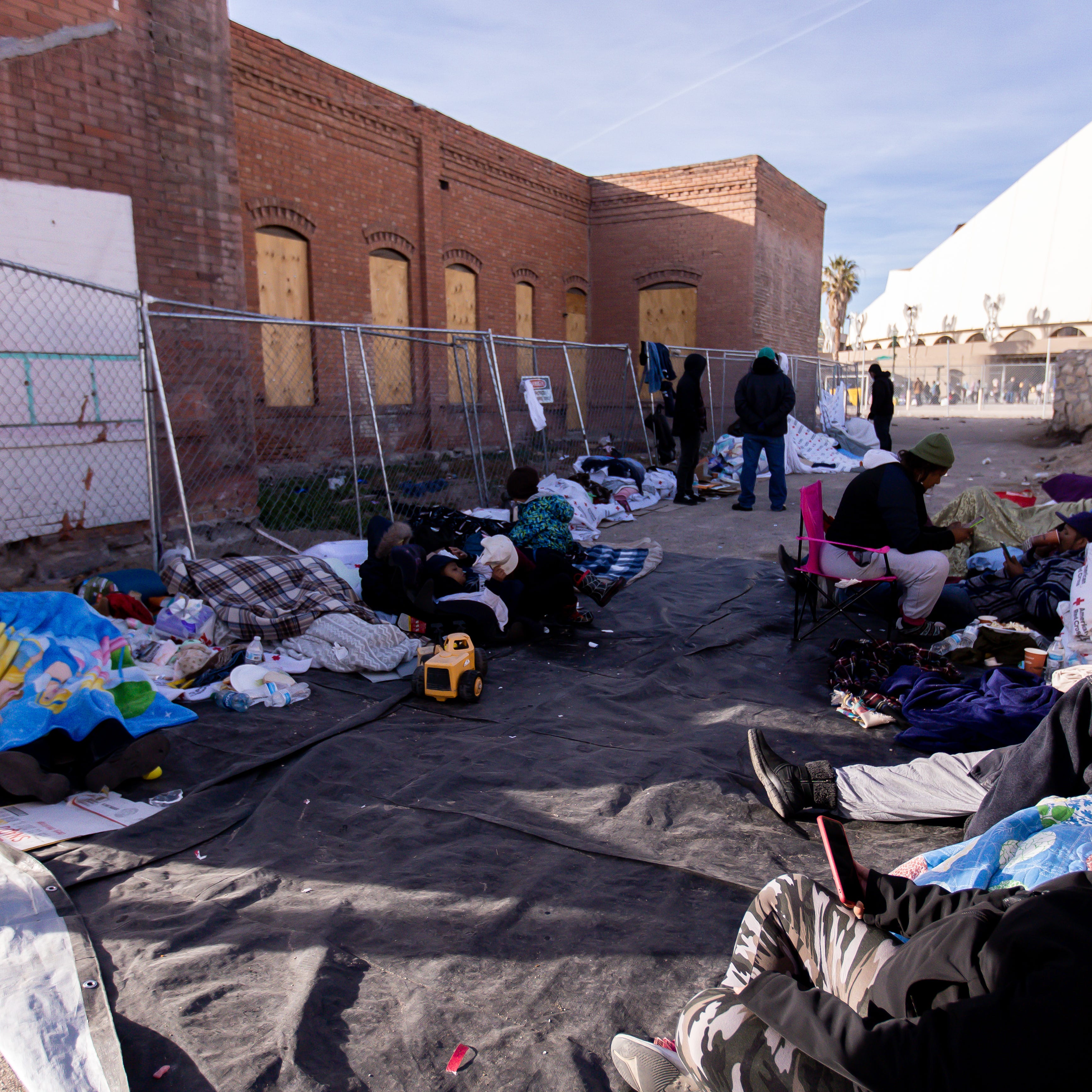 Volunteers bring food, water, blankets, clothes, etc., to migrants who sleep on the streets of El Paso, Texas, on Saturday, Dec. 17, 2022, after being released after crossing into the U.S.