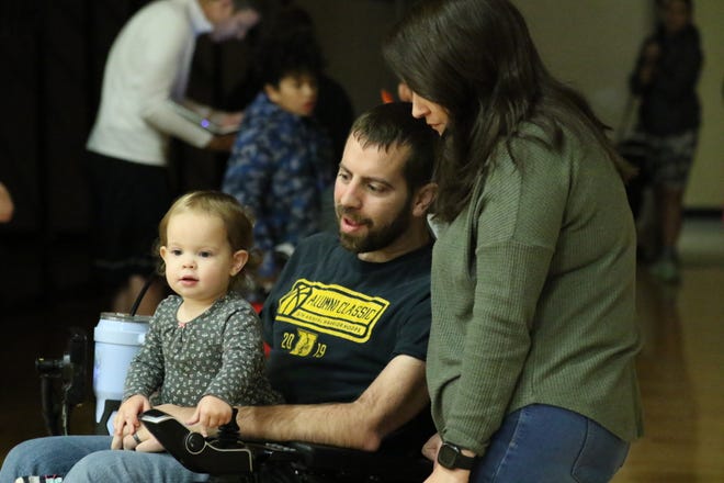 Keegan Hale, a 2009 Westerville North graduate, spends time with his wife, Mikie, and daughter, Blake, before the Ultimate Warrior basketball camp Dec. 17 at the school. The camp was held to help raise money for Hale and his family as he battles Lou Gehrig’s disease.