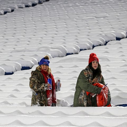 Buffalo Bills fans clear the snow off their seats 
