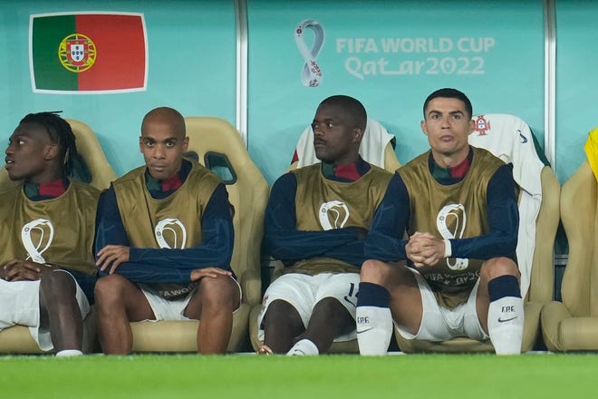 De Portugese Cristiano Ronaldo, rechts, zit op de bank tijdens de WK-kwartfinale voetbalwedstrijd tegen Marokko.