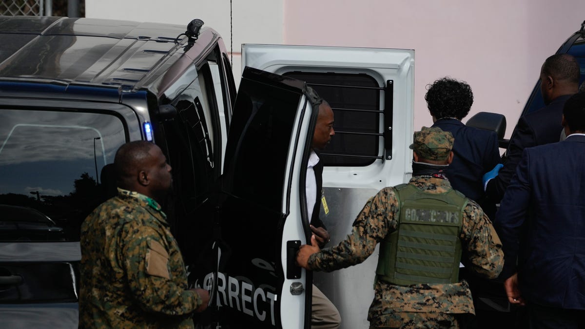 FTX founder Sam Bankman-Fried, top right, is escorted from a corrections van into the Magistrate Court in Nassau, Bahamas, Monday, Dec. 19, 2022.