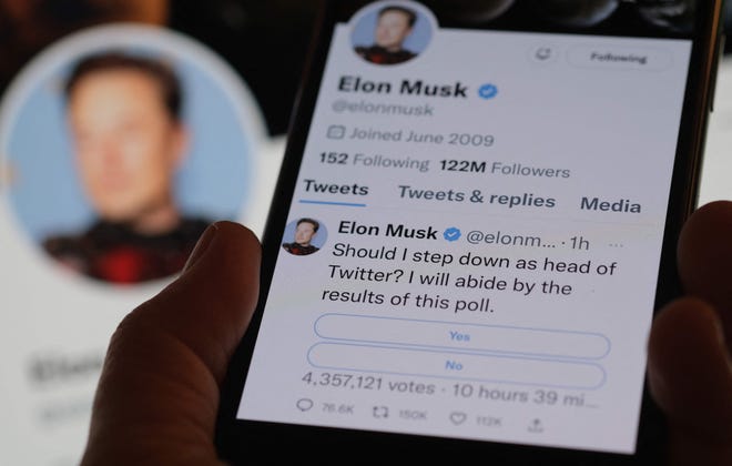 This photo illustration taken on December 18, 2022 in Los Angeles shows a phone displaying Elon Musk's Twitter page where he is conducting a survey about his future as the head of the company. Twitter announced on December 18 it would no longer allow users to promote their accounts on several rival social media platforms including Facebook and Instagram, but the site's mercurial owner Elon Musk appeared to backtrack on the new policy just hours later.