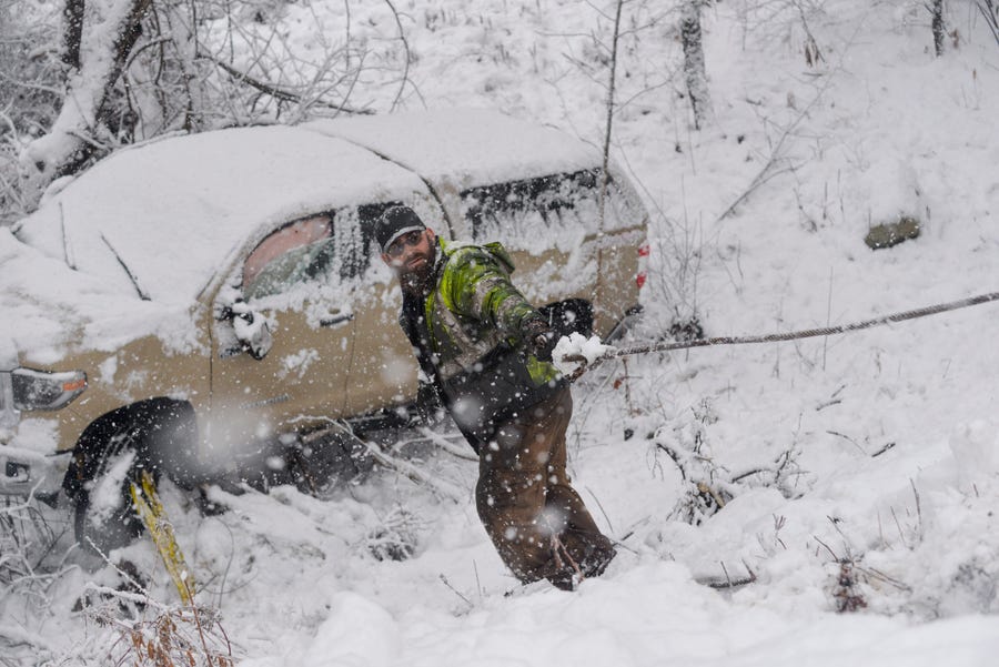 A crew from A's Auto and Truck Repair in Guilford helps clean up one of the two three-vehicle crashes along Route 30 in Jamaica, Vt., during a snowstorm on Friday, Dec. 16, 2022.Â  (Kristopher Radder/The Brattleboro Reformer via AP)