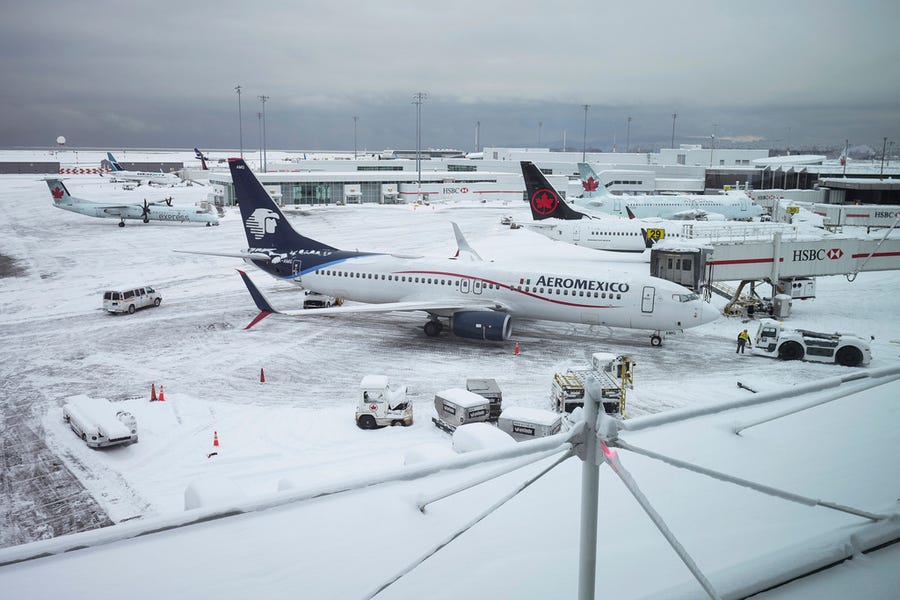 Aircraft are seen parked at gates at Vancouver International Airport after a snowstorm crippled operations leading to cancellations and major delays, in Richmond, British Columbia, on Tuesday, Dec. 20, 2022.