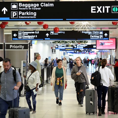 Travelers walk through Miami International Airport