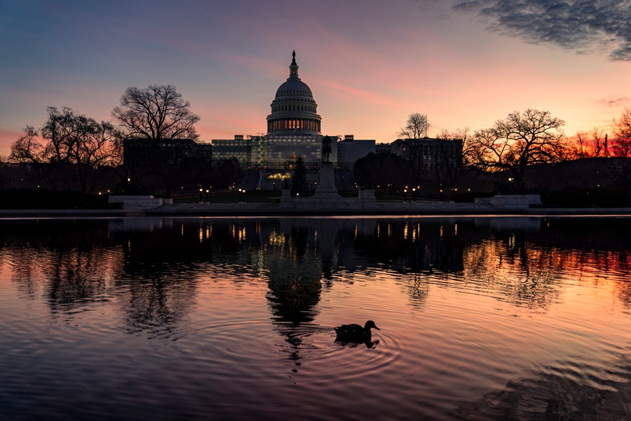 The sun rises behind the Capitol in Washington, early Wednesday, Dec. 14, 2022. Congressional leaders have unveiled a $1.7 trillion spending package early Tuesday, Dec. 20, 2022, that includes another large round of aid to Ukraine, a nearly 10% boost in defense spending and roughly $40 billon to assist communities across the country recovering from drought, hurricanes and other natural disasters.