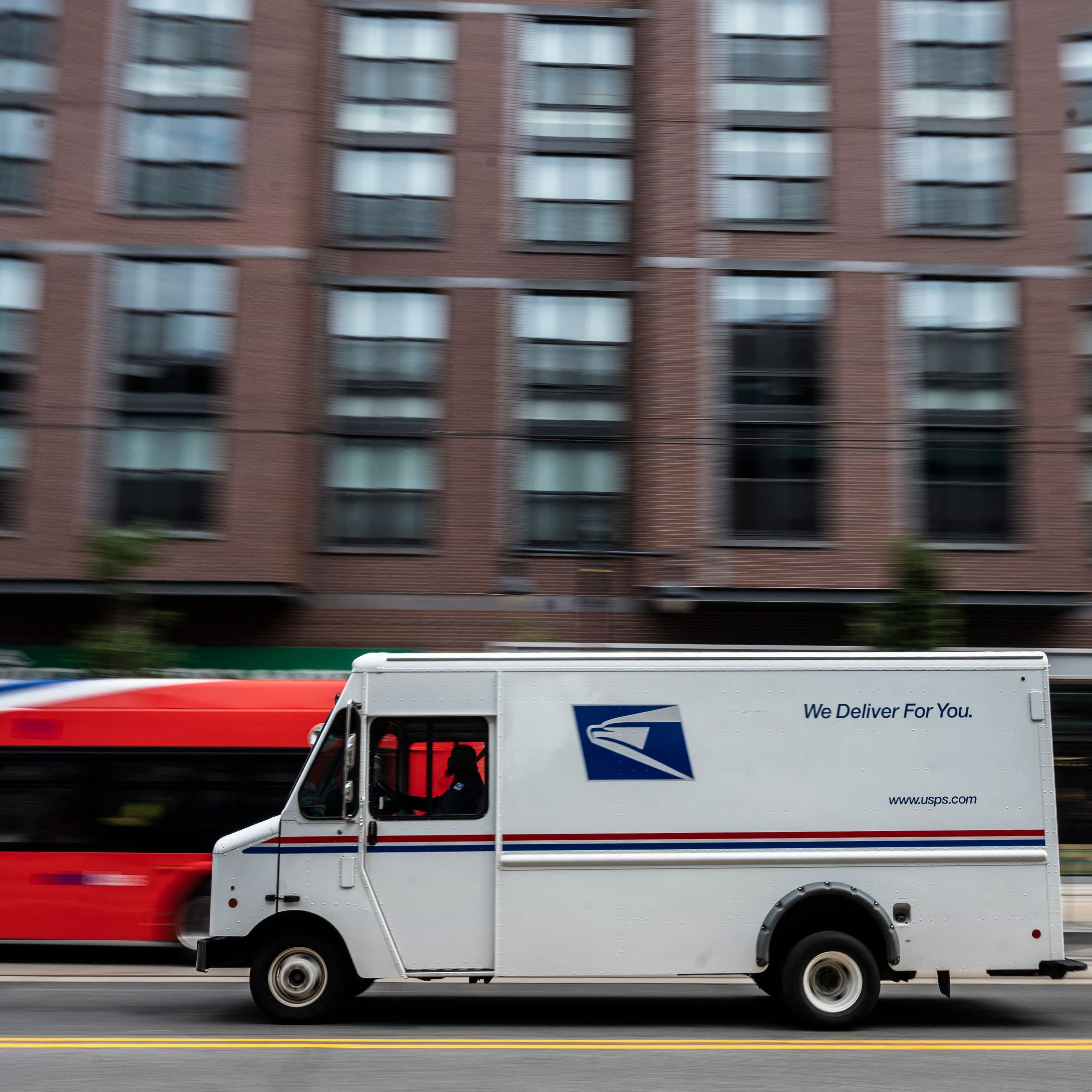 A postman drives a United States Postal service (USPS) mail delivery truck through Washington, DC on August 13, 2021. (Photo by ANDREW CABALLERO-REYNOLDS / AFP) (Photo by ANDREW CABALLERO-REYNOLDS/AFP via Getty Images) ORG XMIT: 0 ORIG FILE ID: AFP_9L433M.jpg
