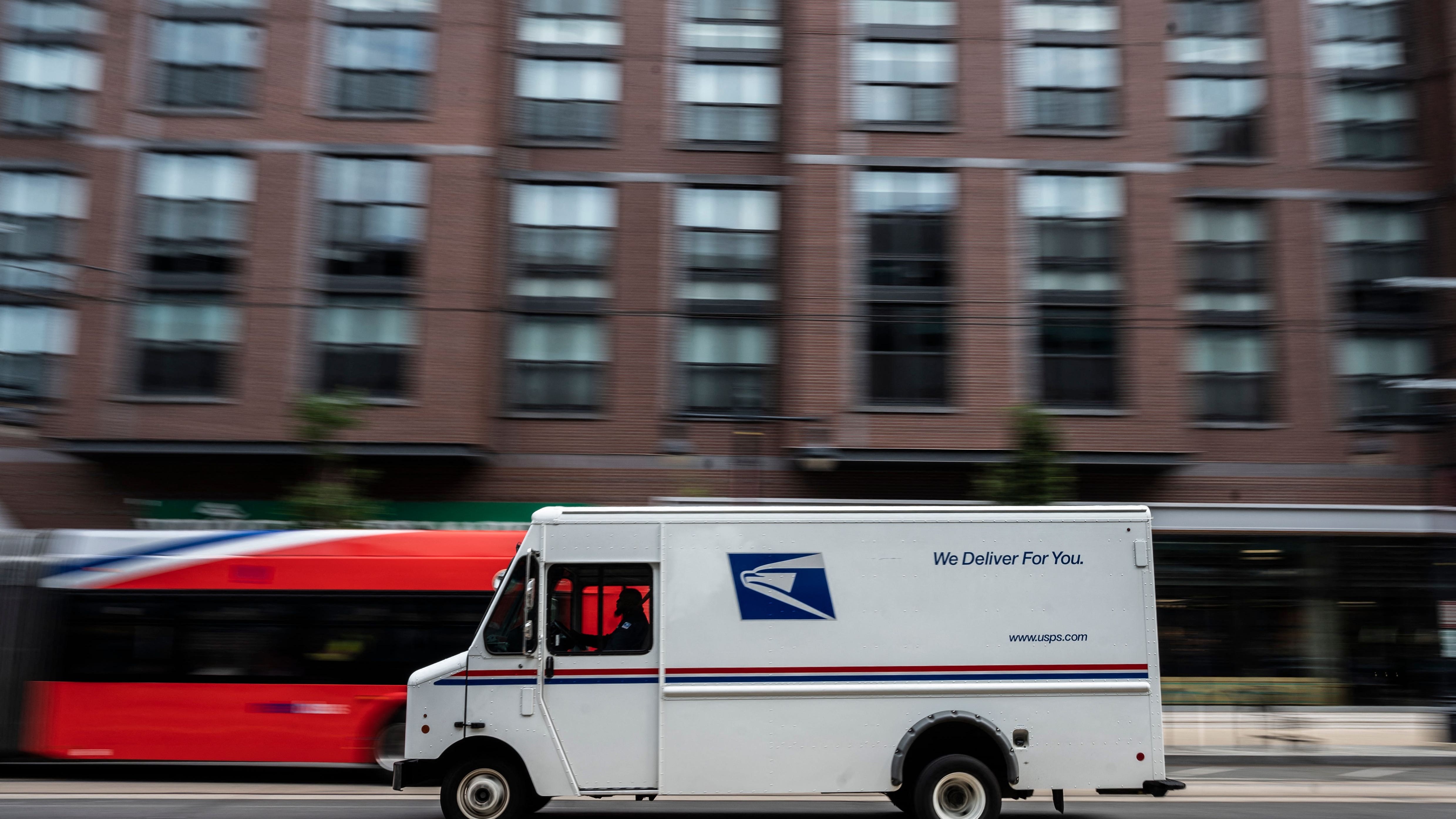 A postman drives a United States Postal service (USPS) mail delivery truck through Washington, DC on August 13, 2021. (Photo by ANDREW CABALLERO-REYNOLDS / AFP) (Photo by ANDREW CABALLERO-REYNOLDS/AFP via Getty Images) ORG XMIT: 0 ORIG FILE ID: AFP_9L433M.jpg