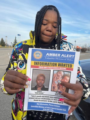 Dec 21, 2022; Dayton, Ohio, USA; Wilhelmina Barnett, mother of twins Kason and Kyair Thomas, holds up an information wanted sign in a Walmart parking lot in Dayton. Columbus police have identified Nalah T. Jackson, 24, as their prime suspect in the abduction and on Tuesday afternoon urged her to return Kason safely. The five-month-old baby's twin brother, Kyair, was found by a passerby sitting in a car seat in the bitter cold early Tuesday in the economy parking lot of Dayton International Airport.