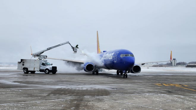 A Southwest Airlines plane undergoes deicing Wednesday at Des Moines International Airport. The time-consuming procedure could contribute to flight delays as a blizzard beings extreme low temperatures to the metro.