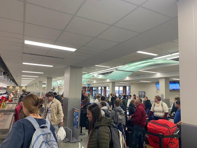 Passengers line up at Des Moines International Airport as a winter storm approaches.