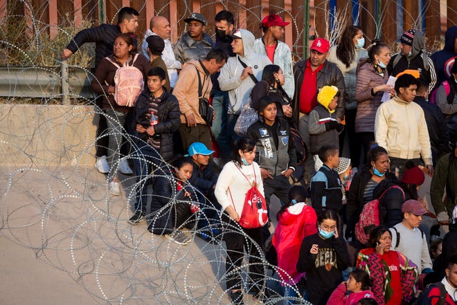 Migranten steken de Rio Grande over en benaderen de Texas National Guard om te vragen wanneer Customs and Border Protection hen asiel zal verlenen, 20 december 2022, in El Paso, Texas.