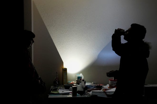 Amelia Valentin, left, watches as her husband, Jarod, drinks a protein shake inside their apartment after an earthquake in Rio Dell, Calif., Tuesday, Dec. 20, 2022. A strong earthquake shook a rural stretch of Northern California early Tuesday, jolting residents awake, cutting off power to thousands of people, and damaging some buildings and a roadway, officials said. (AP Photo/Godofredo A. Vásquez)