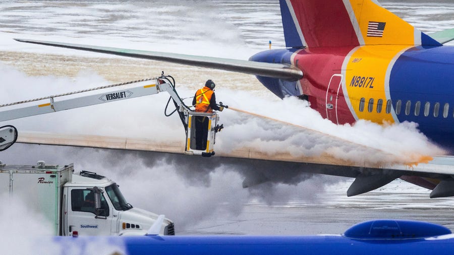 Crews deice a Southwest Airlines plane before takeoff on Wednesday, Dec. 21, 2022 in Omaha, Neb. An incoming winter storm threatens the Christmas travel rush.