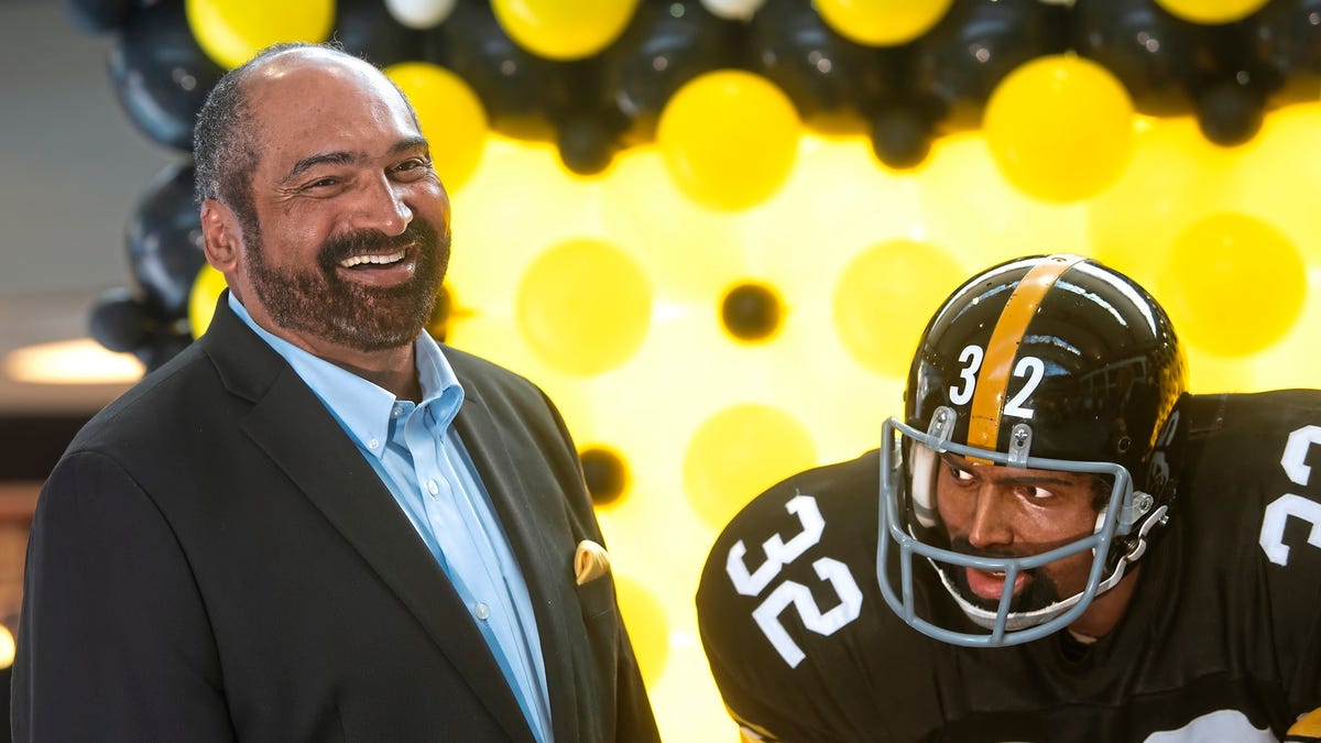 Former Pittsburgh Steelers running back Franco Harris stands next a statute of himself on Sept. 12, 2019.