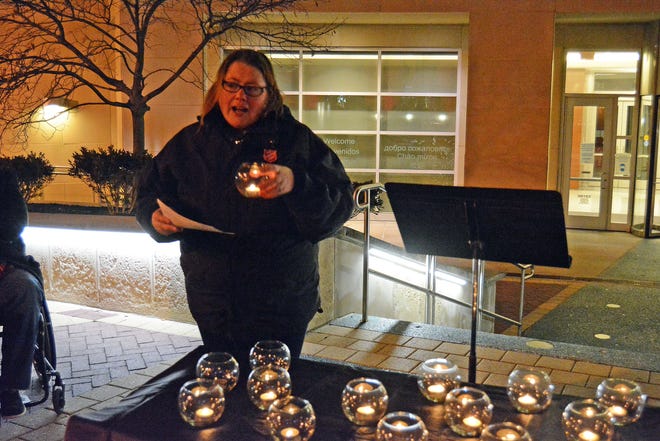 Capt. Amy Cedervall with The Salvation Army prepares to blow out a candle representing one of the 15 unsheltered Columbia residents who died in 2022. 