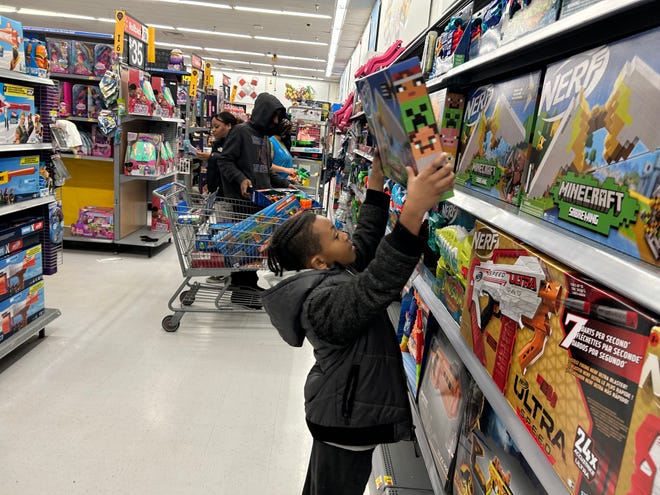 Seven-year-old Chase Coles of Petersburg picks up a Nerf toy from the shelf at Walmart in Colonial Heights on Thursday, Dec. 21.  22nd Feb, 2022. Chase and his fellow Petersburg students participated in the 'Shop with a Hero' program where they were accompanied by first responders to choose gifts for Christmas.