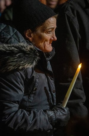 Debbie Goodwin holds a candle during the 32nd annual Longest Night Vigil for the city's homeless Wednesday night in front of the Mustard Seed food pantry and soup kitchen on Piedmont Street. Goodwin, who is homeless, currently lives in a shelter in the city. The national event is held as a memorial to those who have died as a result of homelessness in the past year.
