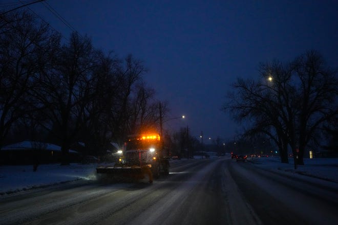 A plow pushes snow off Grand Avenue in West Des Moines on Wednesday.