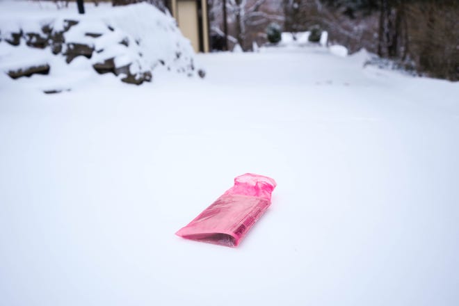 A copy of the Des Moines Register sits in the snow on a driveway on Terrace Road in Des Moines on Thursday.