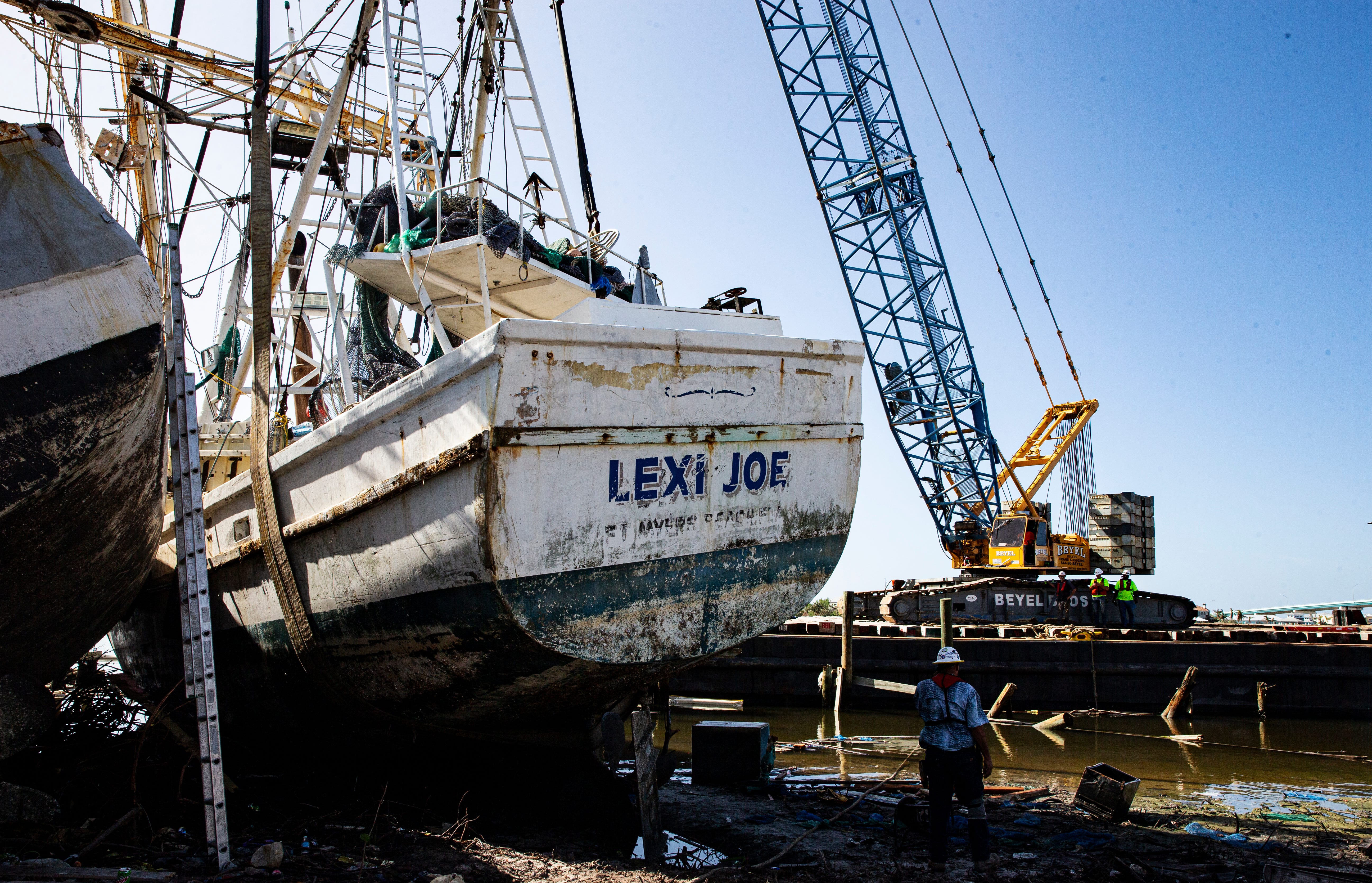 Crew from Beyel Brothers crane company work  on getting the Lexi Joe, a shrimp boat, back in the water on Nov. 8, 2022 at the shrimp docks on Fort Myers Beach. The boat, owned by Henry Gore, was pushed ashore by the storm surge from Hurricane Ian.