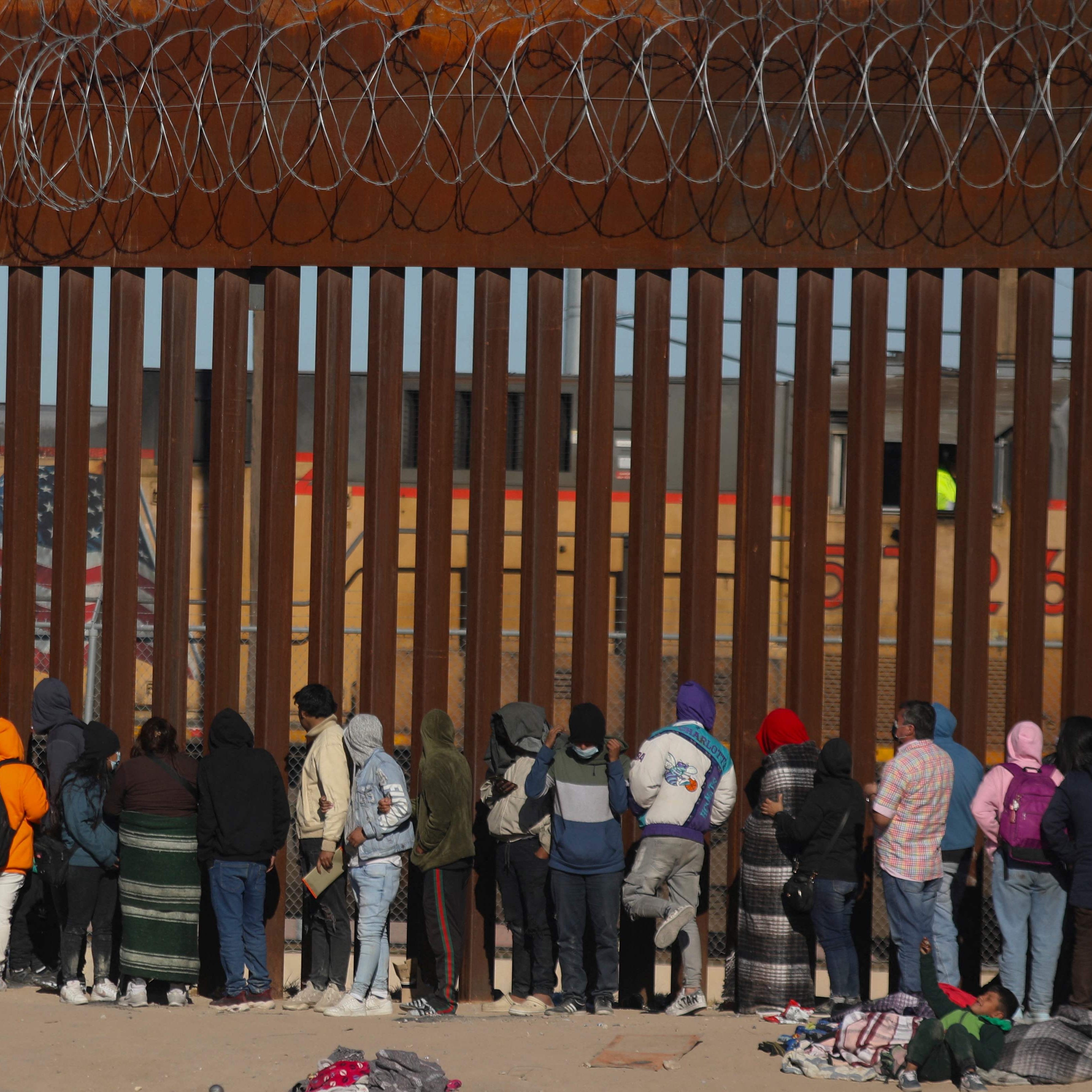 Migrants queue at the border wall to be received by Border Patrol agents after crossing the Rio Bravo river (or Rio Grande river, as it is called in the US) from Ciudad Juarez, Chihuahua state, Mexico, to El Paso, Texas, US on Dec. 21, 2022. - Title 42, a President Donald Trump pandemic-era law that authorizes United States border officials to expel migrants, is supposed to end on Dec. 21.