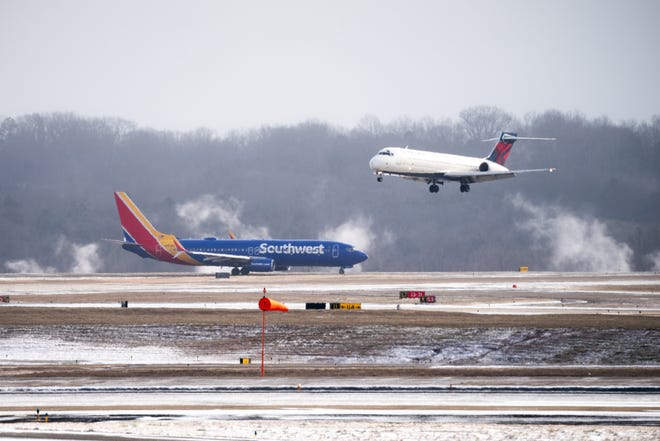 Un vuelo de Delta Airlines aterriza junto a un vuelo de Southwest Airlines en el Aeropuerto Internacional de Nashville en Nashville, Tennessee, el viernes 23 de diciembre de 2022. Las temperaturas bajaron durante la noche, lo que convirtió la lluvia en nieve en Nashville y el centro de Tennessee.