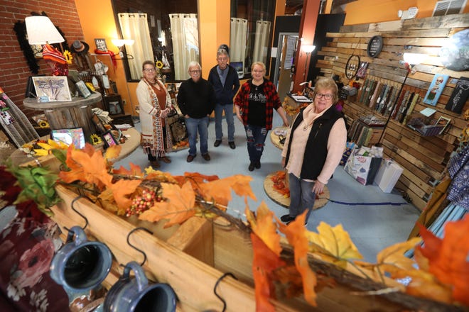 Gail Smith, left, Bob Grayson, Rick Buck, Laura May and Lurenda Hayes all lost businesses in the Masonic Temple fire, and all have bounced back since. They are pictured in May's Oh So Metro Jewelry and Design in Zanesville.