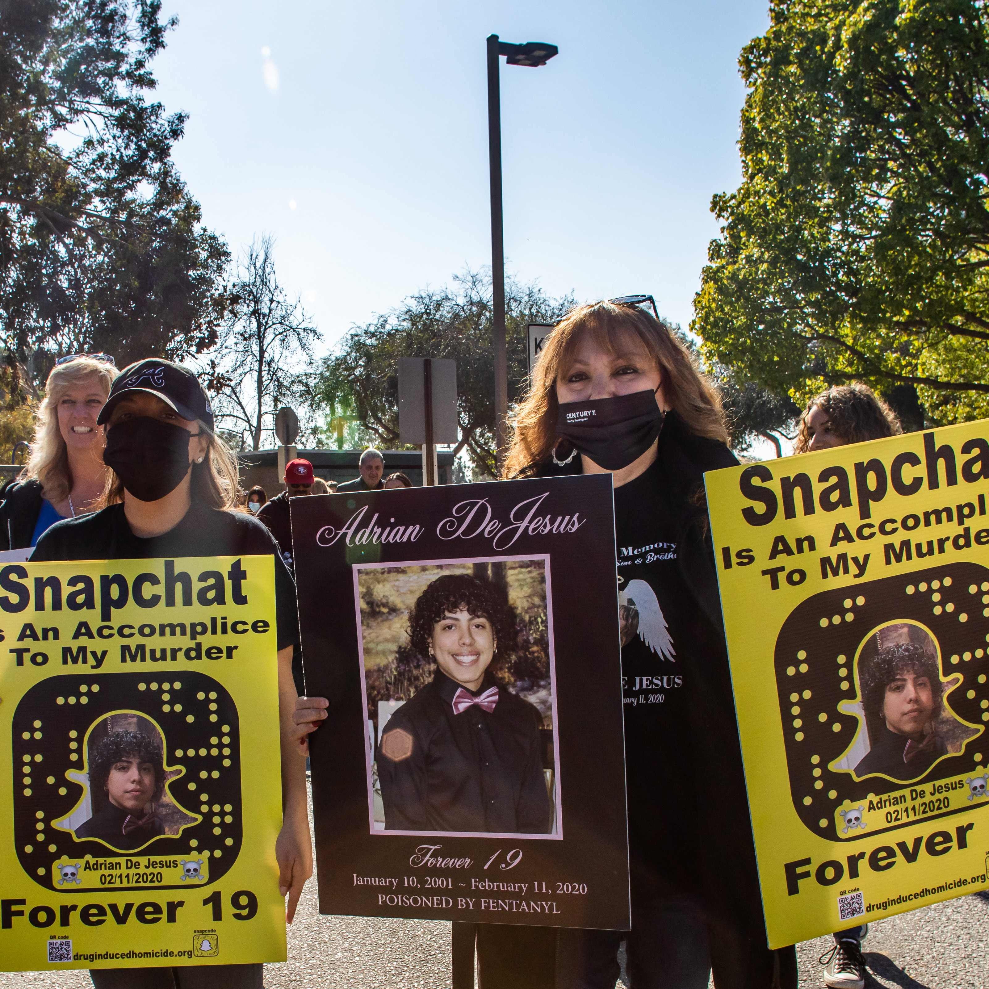 Maria Ortega (R) holds a picture of her son Adrian De Jesus, who  died from fentanyl poisoning, protests against illicit drug availability to children on the app Snapchat near the Snap Inc. headquarters, in Santa Monica, California on January 21, 2022.