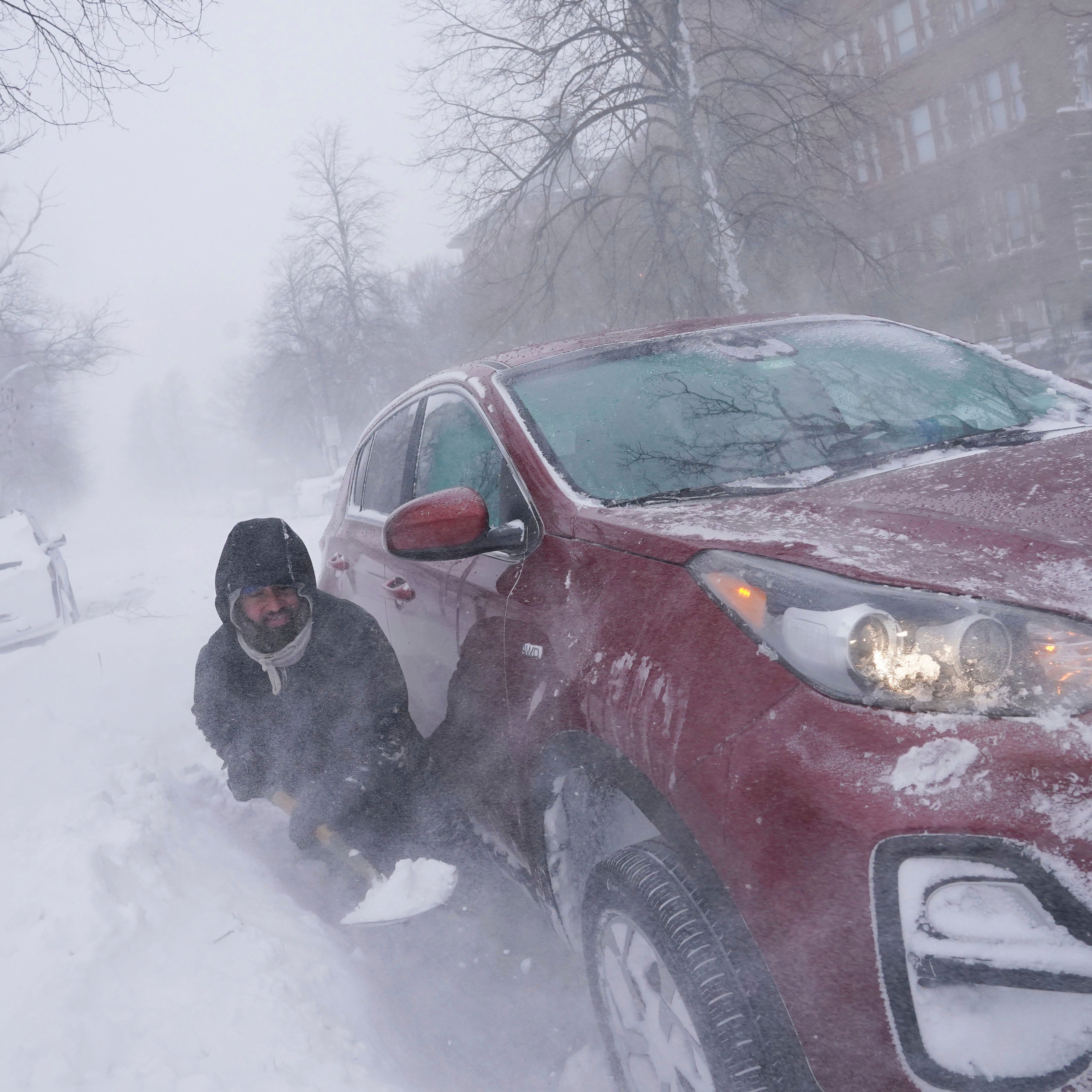 Gamaliel Vega tries to dig out his car on Lafayette Avenue after he got stuck in a snowdrift about a block from home while trying to help rescue his cousin, who had lost power and heat with a baby at home across town during a blizzard in Buffalo, N.Y., on Saturday, Dec. 24, 2022.