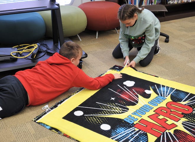Fifth-graders Braxton Smith and Madeline Thomas make a blanket for distribution to a child in need part of a project at Coshocton Elementary School. About 90 kids made 55 blankets for the project's fourth year.