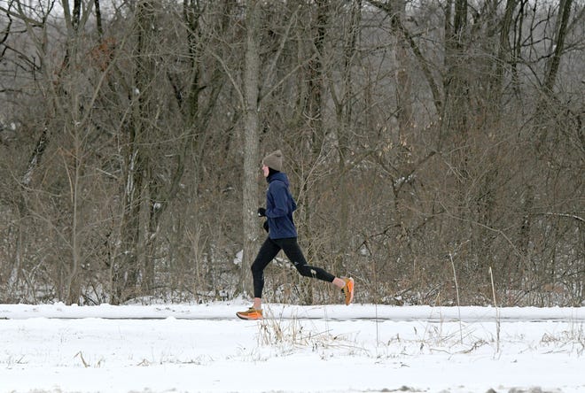 A runner braves the snow and cold Tuesday morning exercising on the Richland B&O Trail. Temperatures are predicted to continue rise over the next few days.
