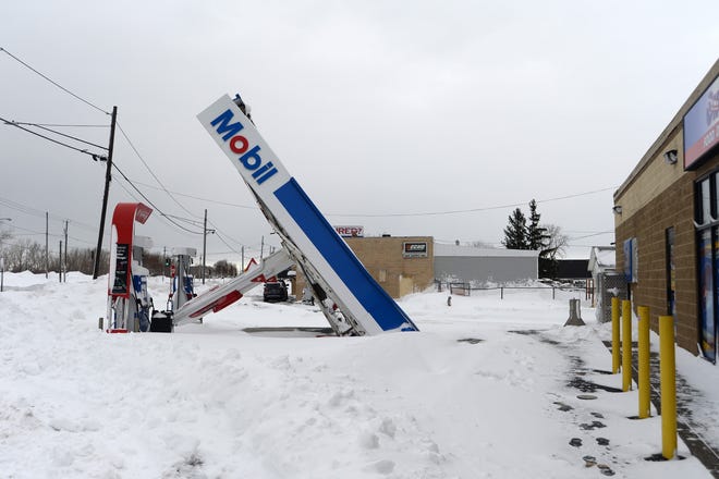 A gas station canopy lays on its side after high winds and heavy snowfall hit Lackawanna, New York.