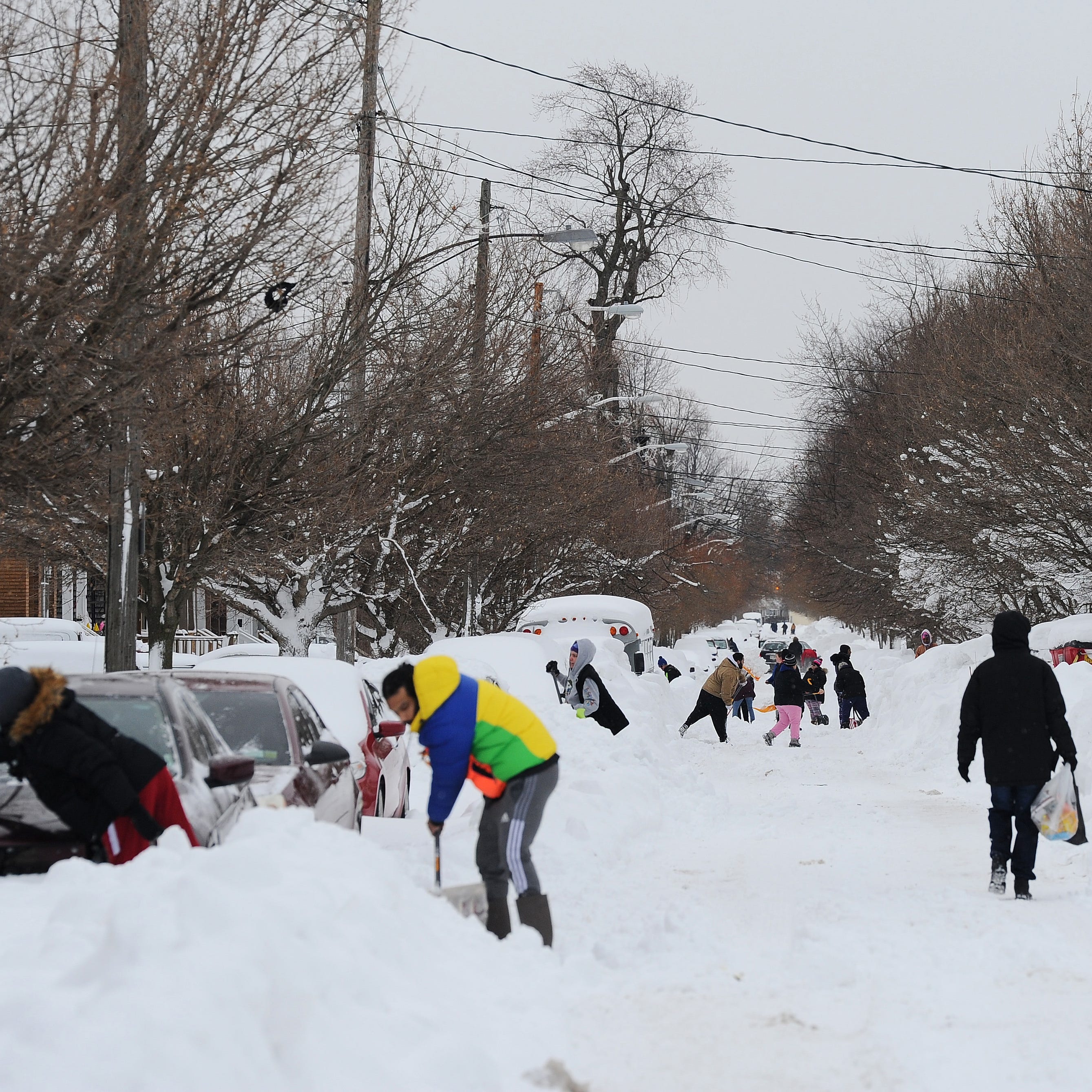 Residents on Woodside Drive clear heavy snow on December 27, 2022 in Buffalo, New York. The historic winter storm Elliott dumped up to four feet of snow, leaving thousands without power and at least 28 confirmed dead in the city of Buffalo and the surrounding suburbs.