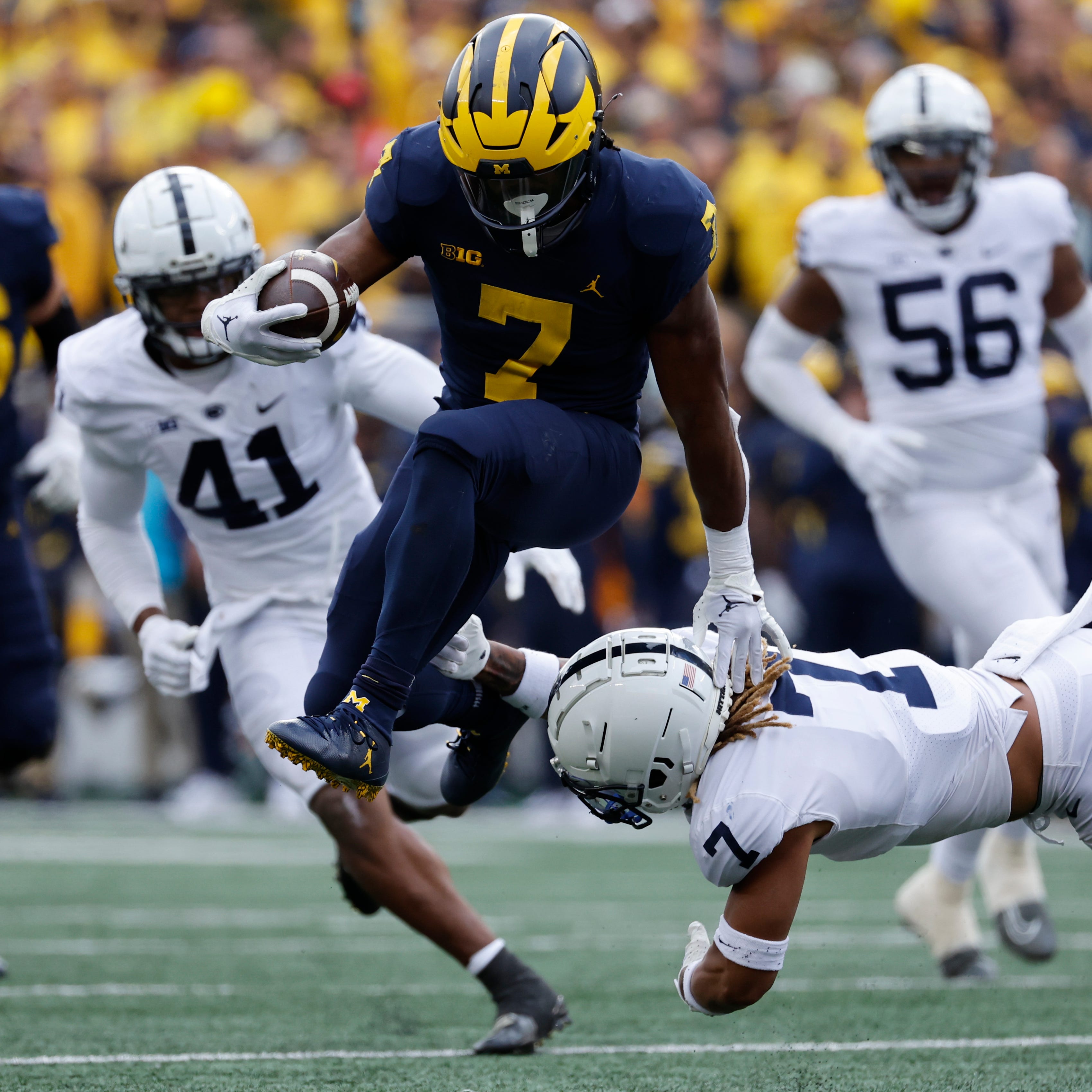 Michigan running back Donovan Edwards (7) avoids a Penn State defender while carrying the ball at Michigan Stadium.