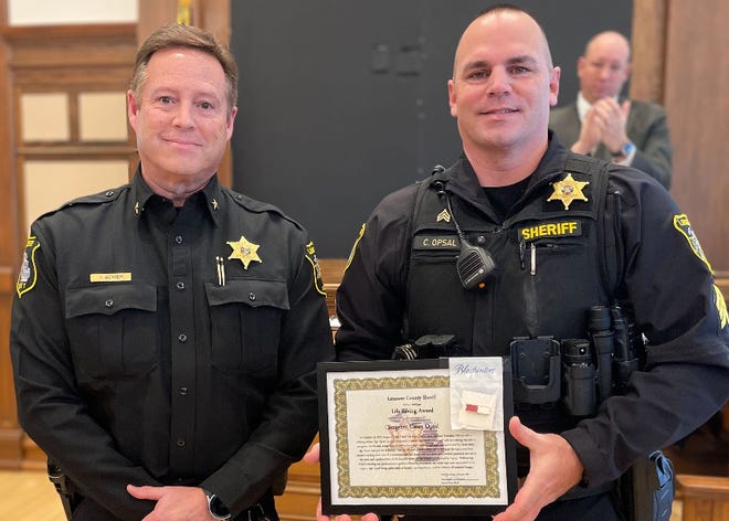 Sgt. Casey Opsal of the Lenawee County Sheriff's Office, right, is pictured with Sheriff Troy Bevier after being presented with a Life Saving Award during the county board of commissioners' meeting Dec. 14.