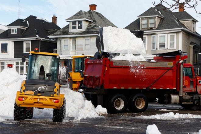 A front end loader dump snow into a dump truck as crews clear large amounts of snow, Wednesday, Dec. 28, 2022, in Buffalo N.Y., days after a winter storm passed through. (AP Photo/Jeffrey T. Barnes)