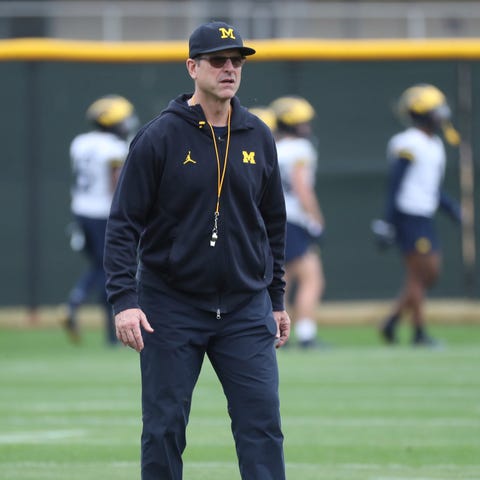 Michigan coach Jim Harbaugh watches drills at the 