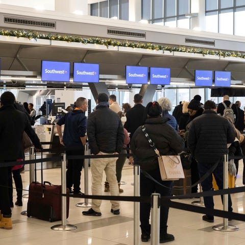 Passengers wait in line to check in for their flig