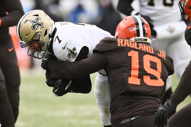 Dec 24, 2022; Cleveland, Ohio, USA; Cleveland Browns linebacker Reggie Ragland (19) tackles New Orleans Saints tight end Taysom Hill (7) during the first half at FirstEnergy Stadium. Mandatory Credit: Ken Blaze-USA TODAY Sports
