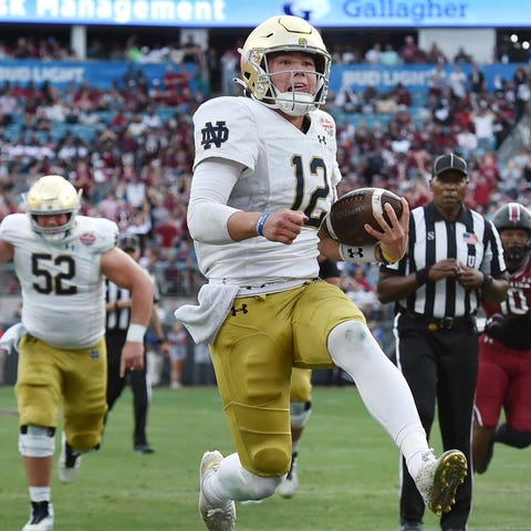 Notre Dame quarterback Tyler Buchner high-steps in