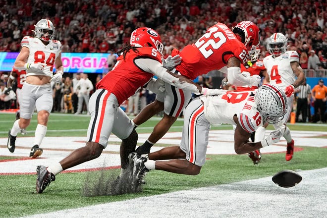 Ohio State wide receiver Marvin Harrison Jr. (18) takes a hit from Georgia defensive back Javon Bullard (22). The hit knocked Harrison out of the game.