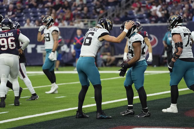 Jacksonville Jaguars running back Snoop Conner (24) is congratulated by quarterback Trevor Lawrence (16) after his touchdown run against the Houston Texans during the second half of an NFL football game in Houston, Sunday, Jan. 1, 2023. (AP Photo/David J. Phillip)