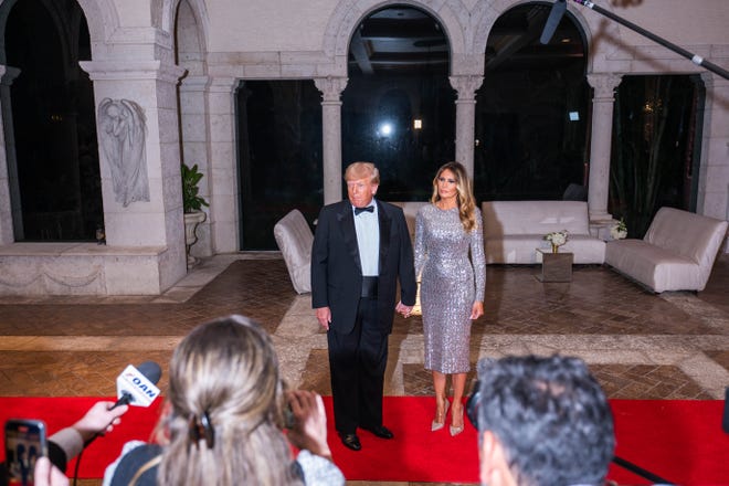 Former President Donald Trump and his wife, Melania Trump, stop to speak to the media at Mar-A-Lago on New Year's Eve in Palm Beach, Fla., Saturday, Dec. 31, 2022.