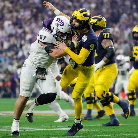 TCU linebacker Johnny Hodges (57) hits Michigan qu